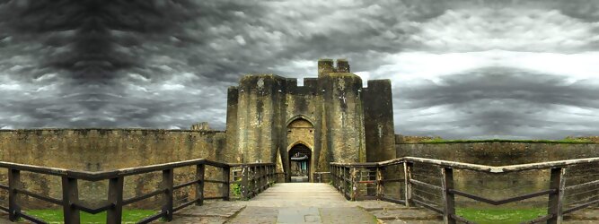 Trip Unterkunft Reisetipps - Caerphilly Castle - ein Bollwerk aus dem 13. Jahrhundert in Wales, Vereinigtes Königreich. Mit einem aufsehenerregenden Turm, der schiefer ist wie der Schiefe Turm zu Pisa. Wie jede Burg mit Prestige, hat sie auch einen Geist, „The Green Lady“ spukt in den Gemächern, wo ihr Geliebter den Tod fand. Wo man in Wales oft – und nicht ohne Grund – das Gefühl hat, dass ein Schloss ziemlich gleich ist, ist Caerphilly Castle bei Cardiff eine sehr willkommene Abwechslung. Die Burg ist nicht nur deutlich größer, sondern auch älter als die Burgen, die später von Edward I. als Ring um Snowdonia gebaut wurden.
