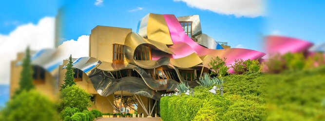 Trip Unterkunft Reisetipps - Marqués de Riscal Design Hotel, Bilbao, Elciego, Spanien. Fantastisch galaktisch, unverkennbar ein Werk von Frank O. Gehry. Inmitten idyllischer Weinberge in der Rioja Region des Baskenlandes, bezaubert das schimmernde Bauobjekt mit einer Struktur bunter, edel glänzender verflochtener Metallbänder. Glanz im Baskenland - Es muss etwas ganz Besonderes sein. Emotional, zukunftsweisend, einzigartig. Denn in dieser Region, etwa 133 km südlich von Bilbao, sind Weingüter normalerweise nicht für die Öffentlichkeit zugänglich.